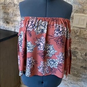 Sleeveless top with ribbon tied sleeves.